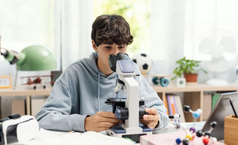 Young student using a microscope