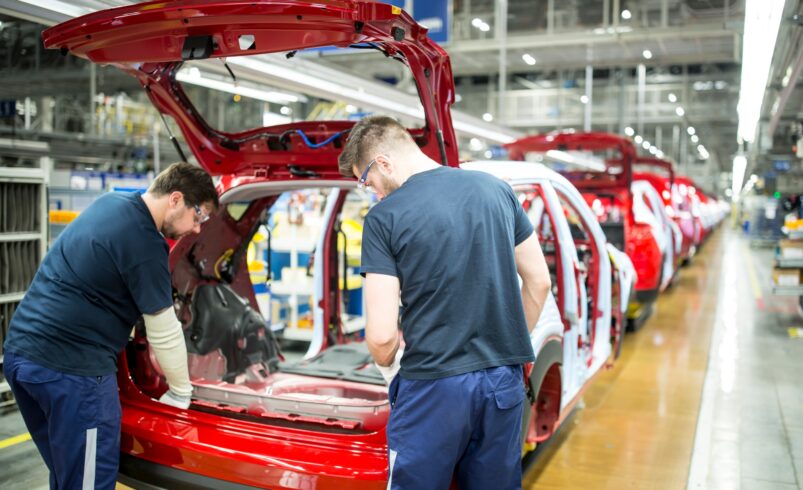 Two colleagues working in modern car factory