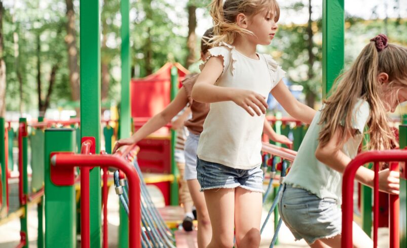 Group of kids playing at the playground in summer day