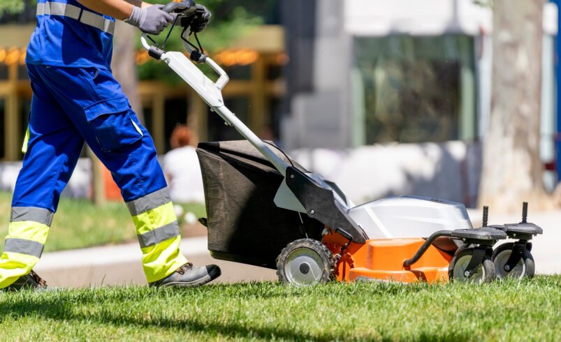 Garden worker mowing the lawn