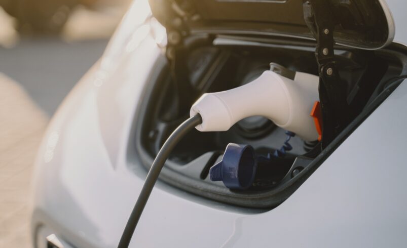 Woman charging electro car at the electric gas station